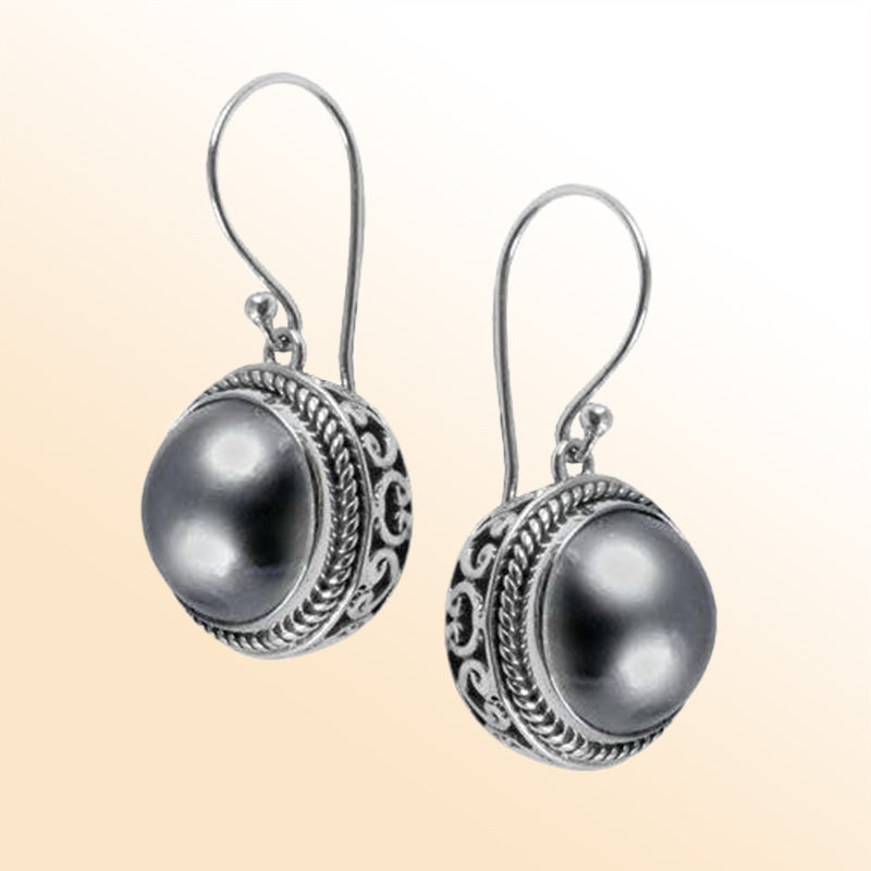 Sterling silver artisan earrings featuring Grey Mabe Pearl in ornate Bali-style detailing with earwire lock.