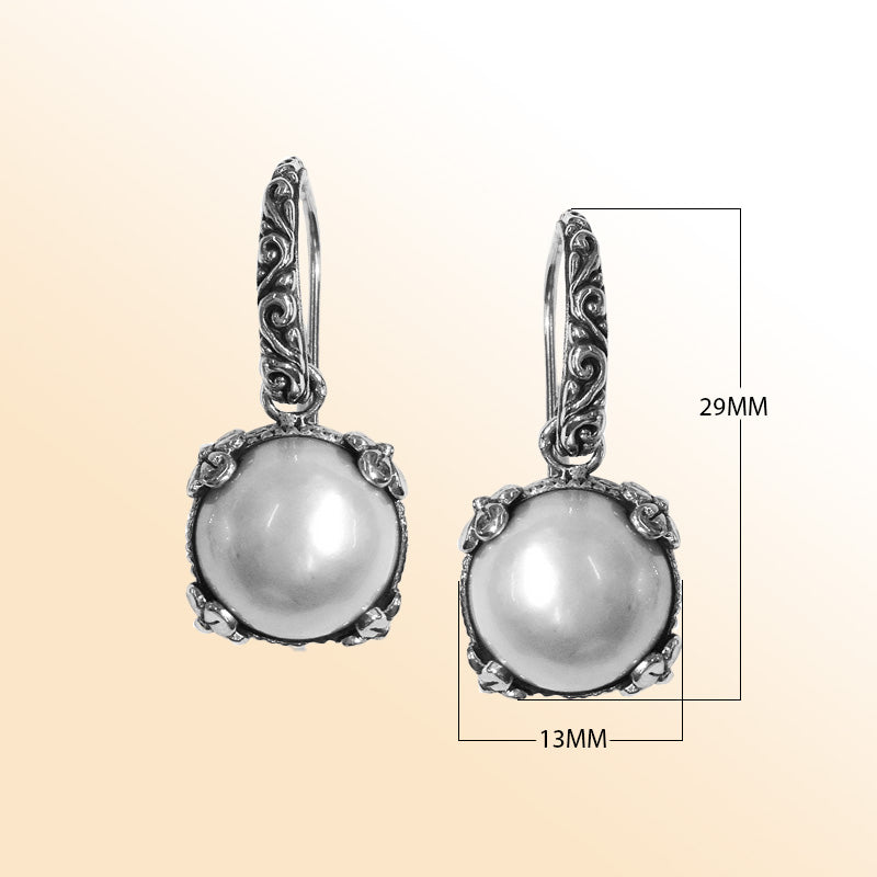 Sterling silver artisan crown-frame Mabe Pearl drop earrings with ornate detailing and earwire lock.