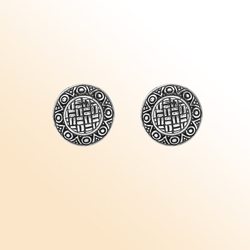 Sterling silver artisan round earrings with carved geometric pattern and omega clip closure.