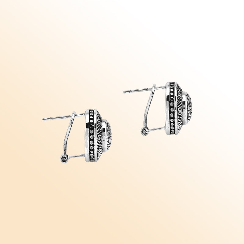 Sterling silver artisan round earrings with carved geometric pattern and omega clip closure.