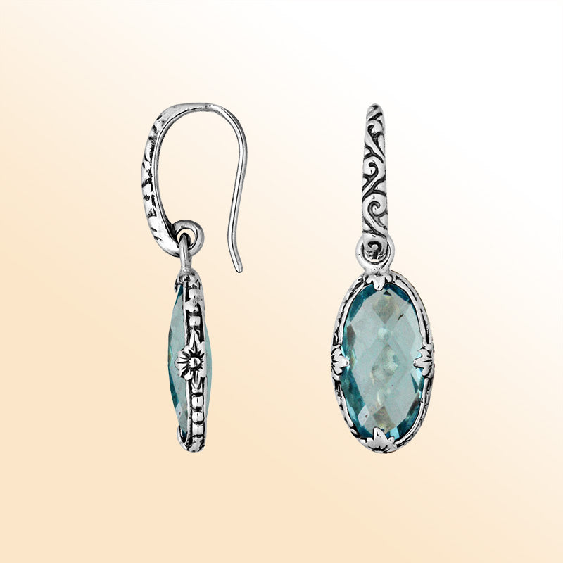 A stunning pair of 925 sterling silver earrings featuring oval Blue Topaz Quartz stones with Balinese floral detailing and earwire hooks for a modern elegant look.