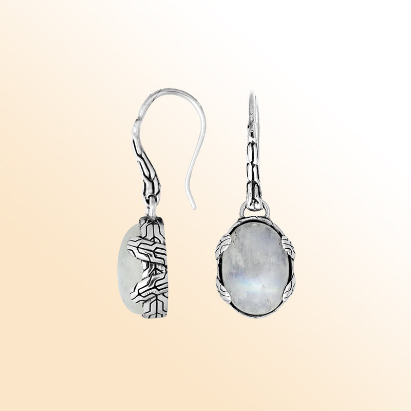 Handcrafted sterling silver Rainbow Moonstone oval drop earrings with antique oxidized texture and celestial glow.