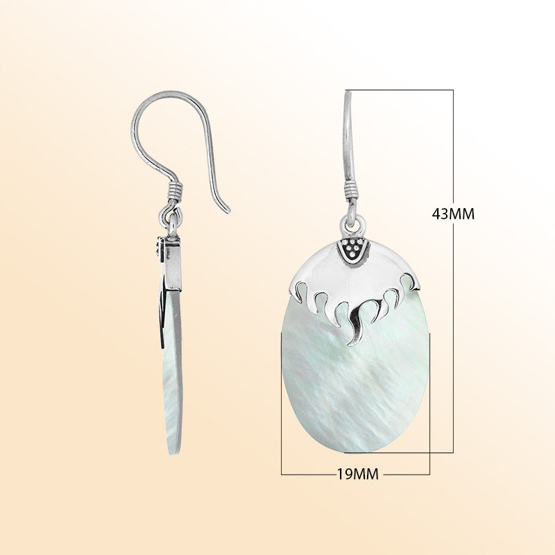 Artisan sterling silver earrings with glowing Mother Of Pearl ovals and a wave-inspired sculpted silver cap.