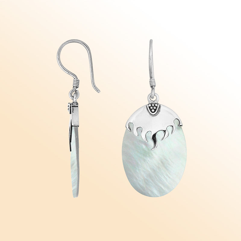 Artisan sterling silver earrings with glowing Mother Of Pearl ovals and a wave-inspired sculpted silver cap.