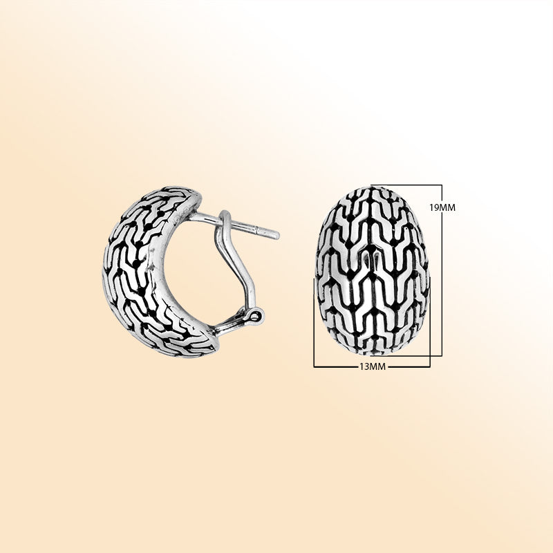 Artisan sterling silver omega-clip hoop earrings with raised oxidized pattern design.