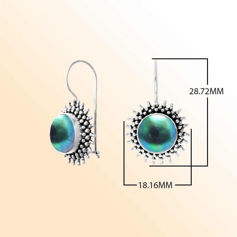 Hand-polished sterling silver earrings featuring luminous green Mabe Pearls set within a detailed sunburst design, completed with artisan-crafted earwire hooks.