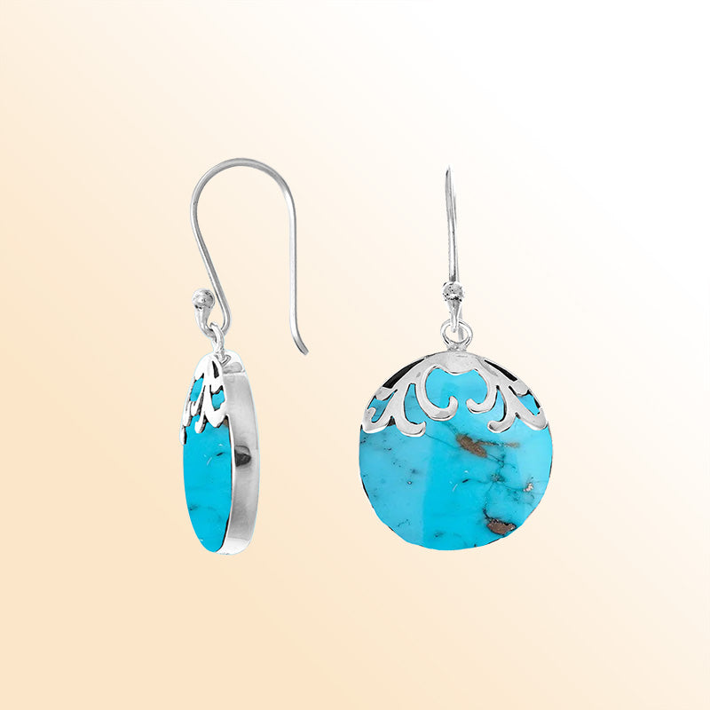 Handcrafted sterling silver dangle earrings featuring Turquoise Shell discs with artistic filigree accents and earwire closure for expressive everyday wear.