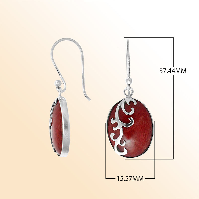 Sterling silver artisan earrings featuring vivid oval red coral with a flowing wave-style overlay, crafted to create an expressive ocean-inspired look for elegant everyday wear.