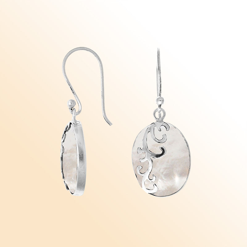 Sterling silver artisan earrings showcasing luminous oval mother of pearl with flowing wave-style overlay, crafted to evoke a serene ocean-inspired look for elegant everyday wear.