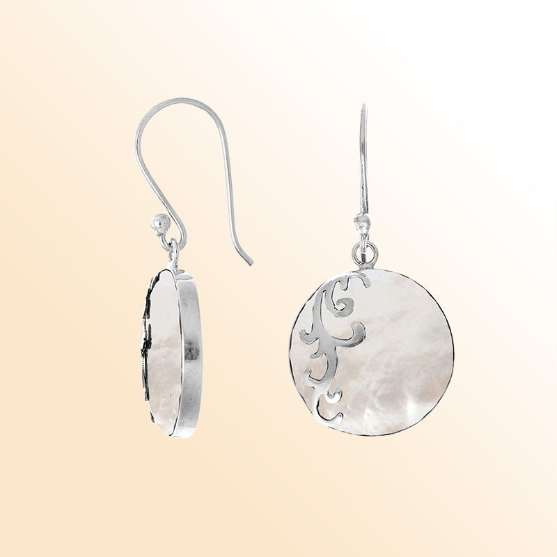 Sterling silver artisan earrings featuring luminous round mother of pearl with a flowing wave-style overlay, designed to evoke a serene ocean-inspired look for expressive, elegant everyday wear.