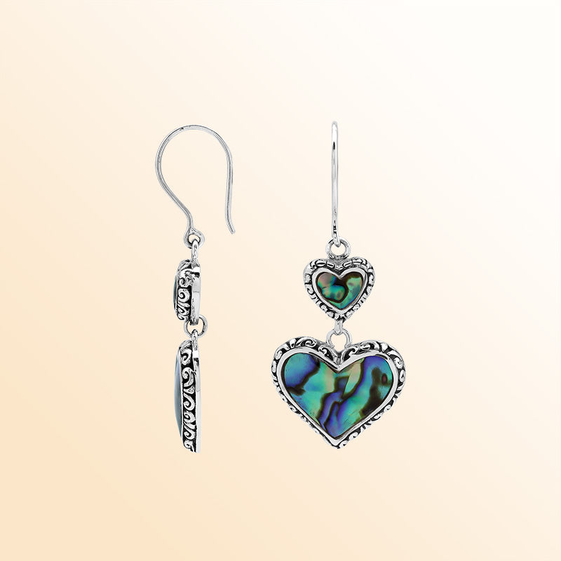 Sterling silver artisan earrings featuring shimmering double abalone shell hearts with ornate decorative borders, crafted to evoke a romantic ocean-inspired look for expressive and elegant everyday wear.