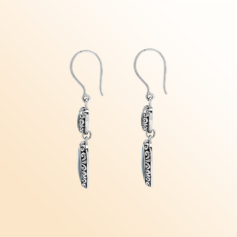 Sterling silver artisan earrings featuring shimmering double abalone shell hearts with ornate decorative borders, crafted to evoke a romantic ocean-inspired look for expressive and elegant everyday wear.