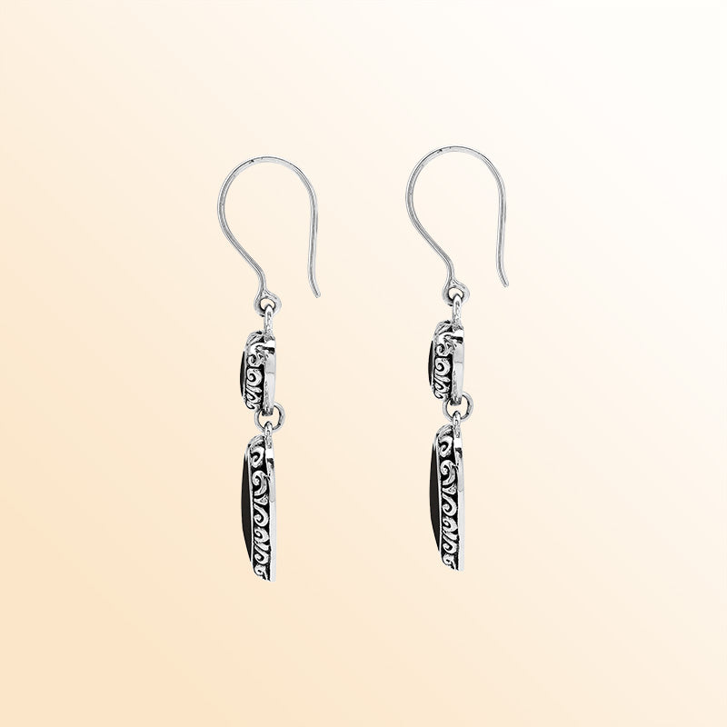 Sterling silver artisan earrings featuring deep-toned black shell double hearts with ornate borders, designed to create an expressive romantic look for elegant and stylish everyday wear.