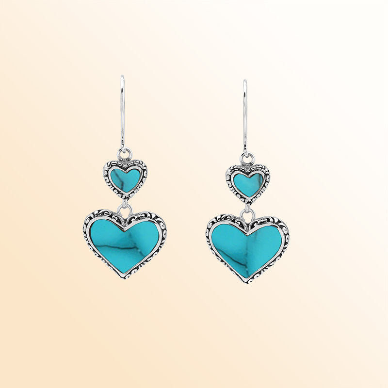 Sterling silver artisan earrings featuring bright turquoise shell double hearts with ornate borders, designed to create an expressive romantic look for elegant and colorful everyday wear.