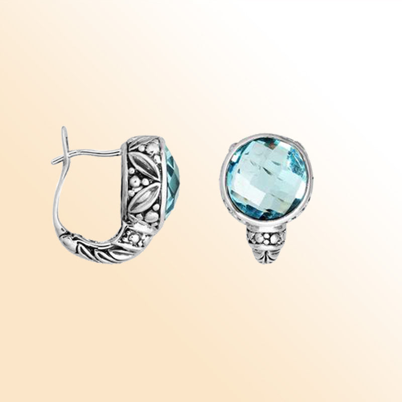 Sterling silver artisan earrings featuring faceted blue topaz quartz with ornate Balinese-inspired detailing, designed to offer elegant, expressive, and comfortable everyday wear with secure omega clip closure.