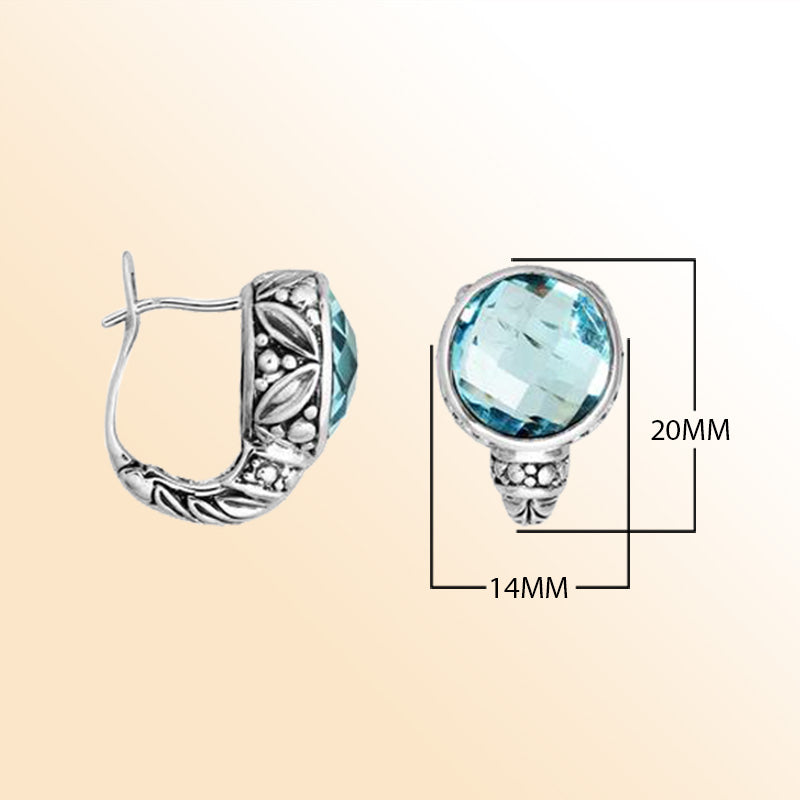 Sterling silver artisan earrings featuring faceted blue topaz quartz with ornate Balinese-inspired detailing, designed to offer elegant, expressive, and comfortable everyday wear with secure omega clip closure.