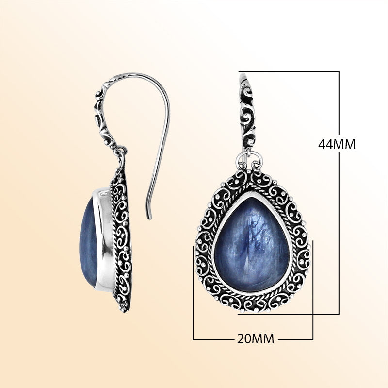 Sterling silver artisan earrings featuring pear-shaped kyanite cabochons surrounded by ornate Balinese-style detailing, designed to offer refined elegance, expressive artistry, and comfortable everyday wear.