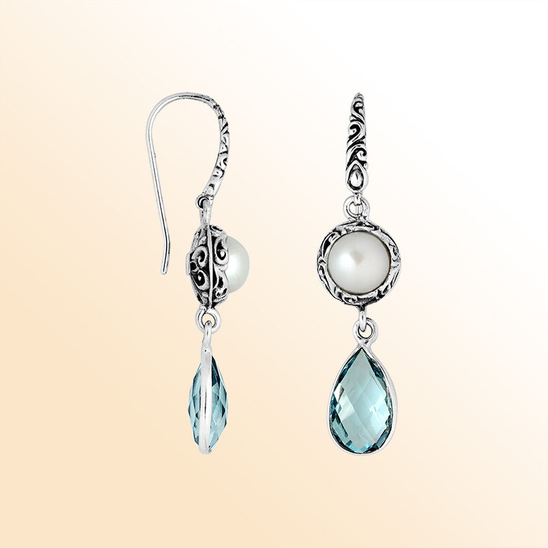 Elegant sterling silver earrings showcasing luminous Mabe Pearls above sparkling teardrop Blue Topaz Quartz with intricate Balinese scroll details and graceful hooks.