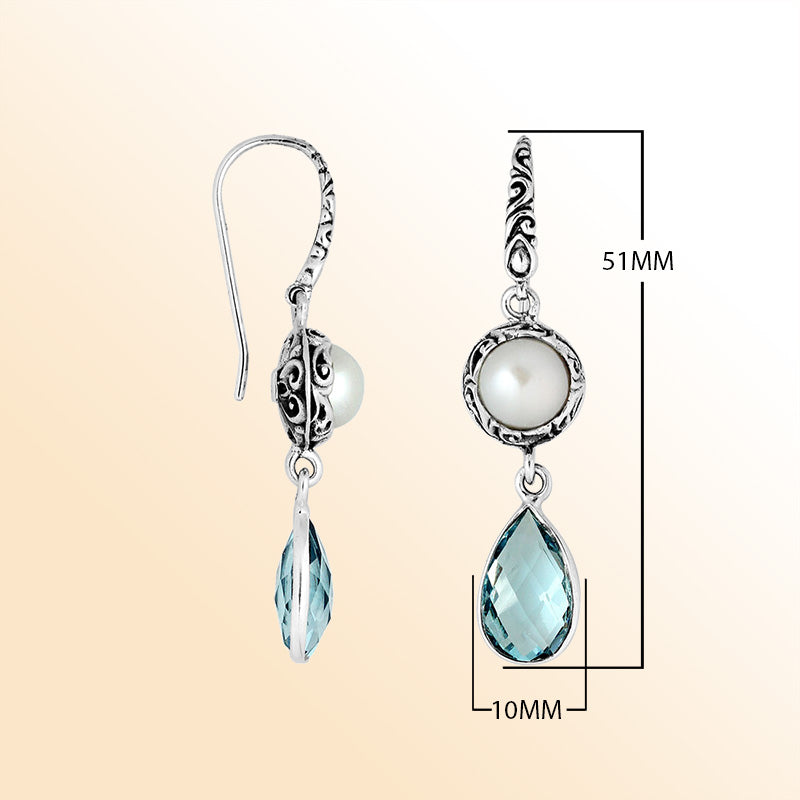 Elegant sterling silver earrings showcasing luminous Mabe Pearls above sparkling teardrop Blue Topaz Quartz with intricate Balinese scroll details and graceful hooks.