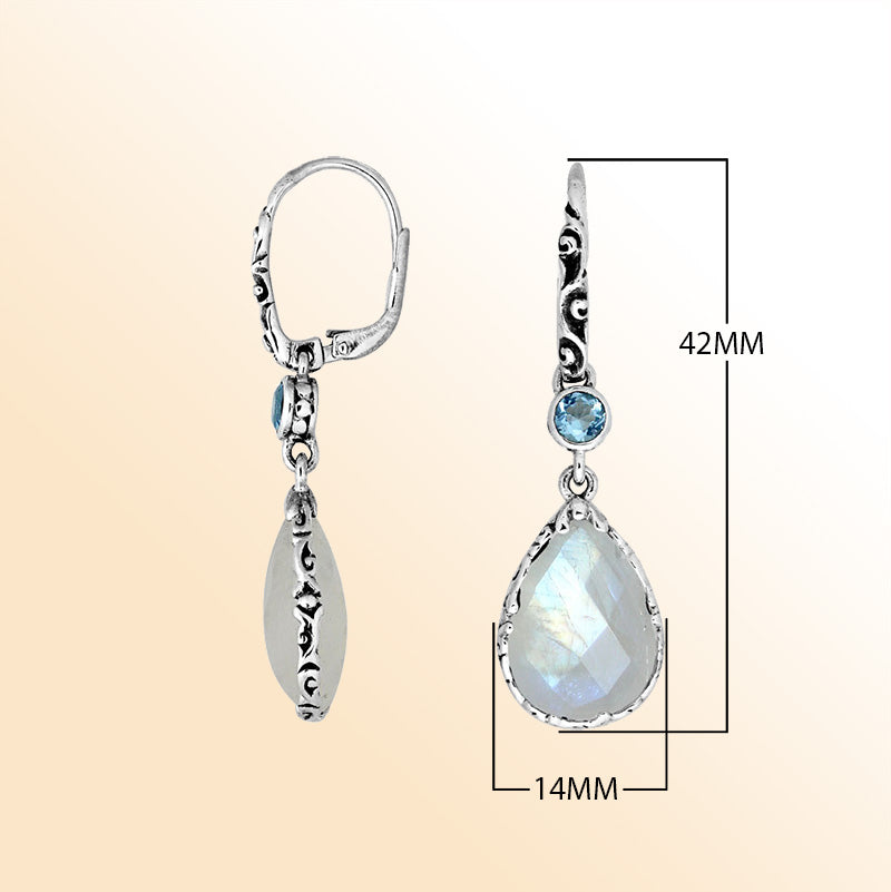 Elegant sterling silver dangle earrings featuring a shimmering Rainbow Moonstone teardrop and a bright Blue Topaz Quartz accent with ornate scroll details and earwire for a refined handcrafted look.