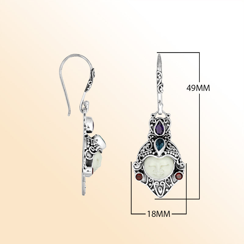 A stunning pair of 925 sterling silver earrings featuring carved bone faces with detailed Balinese filigree and Amethyst Quartz, Blue Topaz Quartz, and Garnet Quartz stones.