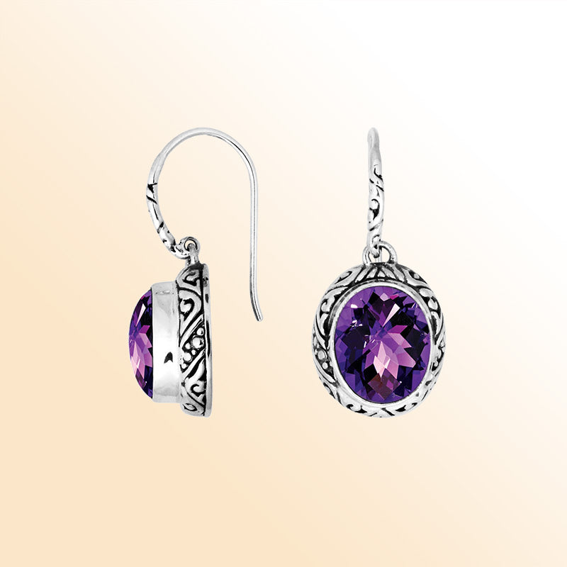 Sterling silver earrings featuring a radiant faceted oval Amethyst Quartz stone framed with artistic carved detailing and earwire lock, creating expressive color and handcrafted elegance for everyday wear.