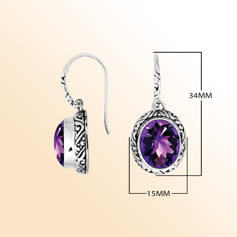 Sterling silver earrings featuring a radiant faceted oval Amethyst Quartz stone framed with artistic carved detailing and earwire lock, creating expressive color and handcrafted elegance for everyday wear.