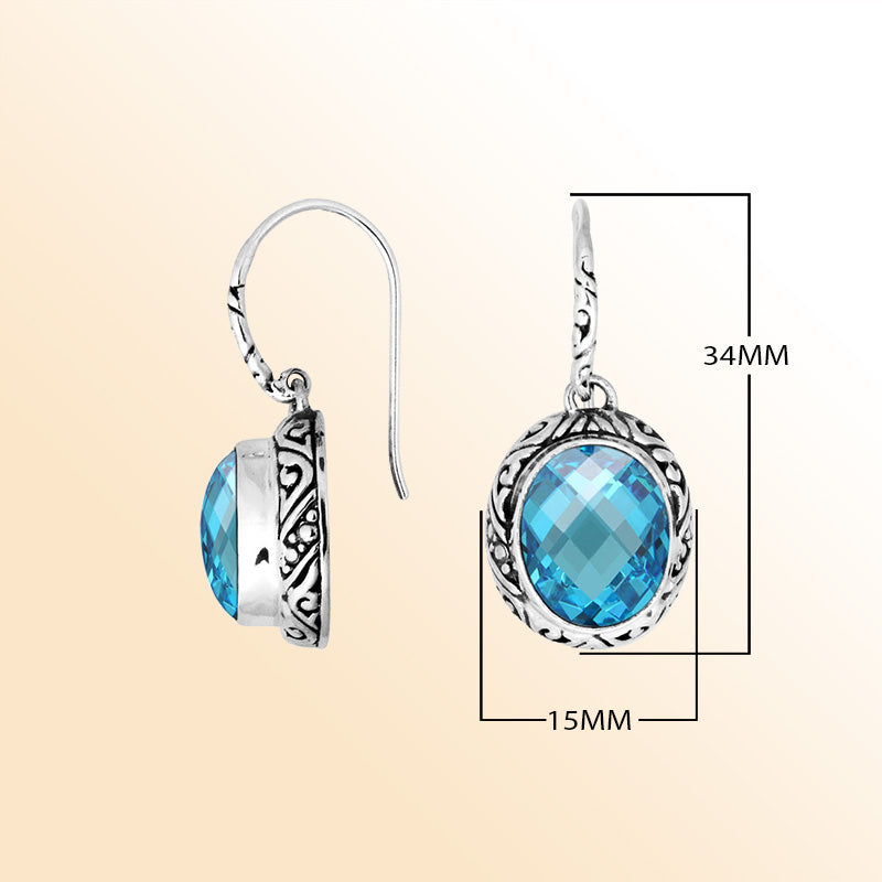 Sterling silver earrings featuring a luminous faceted oval Blue Topaz Quartz stone surrounded by carved detailing with an earwire lock, offering radiant color and artistic handcrafted elegance for everyday wear.