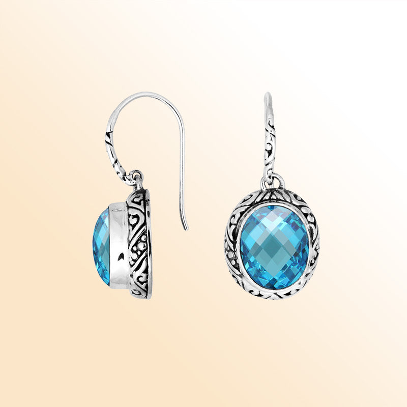 Sterling silver earrings featuring a luminous faceted oval Blue Topaz Quartz stone surrounded by carved detailing with an earwire lock, offering radiant color and artistic handcrafted elegance for everyday wear.