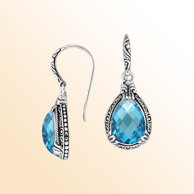 Sterling silver earrings featuring a radiant faceted Blue Topaz Quartz teardrop framed with ornate carved detailing and earwire lock, offering bright sparkle and handcrafted elegance for everyday wear.