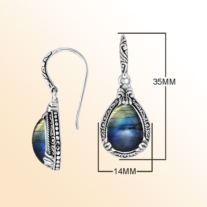 Sterling silver earrings featuring a glowing Labradorite teardrop with blue and gold iridescence, framed in ornate carved detailing and secured with an earwire lock for enchanting, handcrafted everyday elegance.