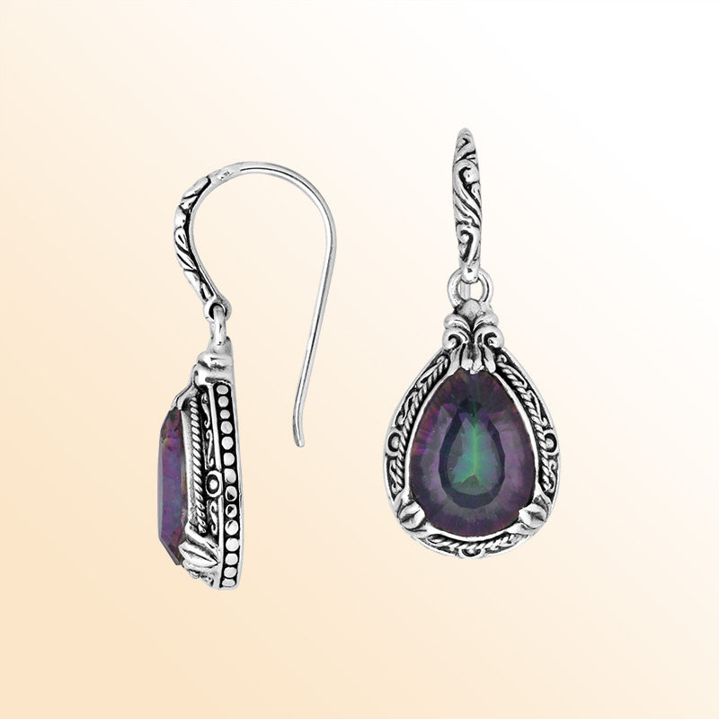 Sterling silver earrings featuring a prismatic Mystic Quartz teardrop displaying shifting purple and green tones, framed with ornate carved detailing and secured with an earwire lock for radiant handcrafted everyday elegance.