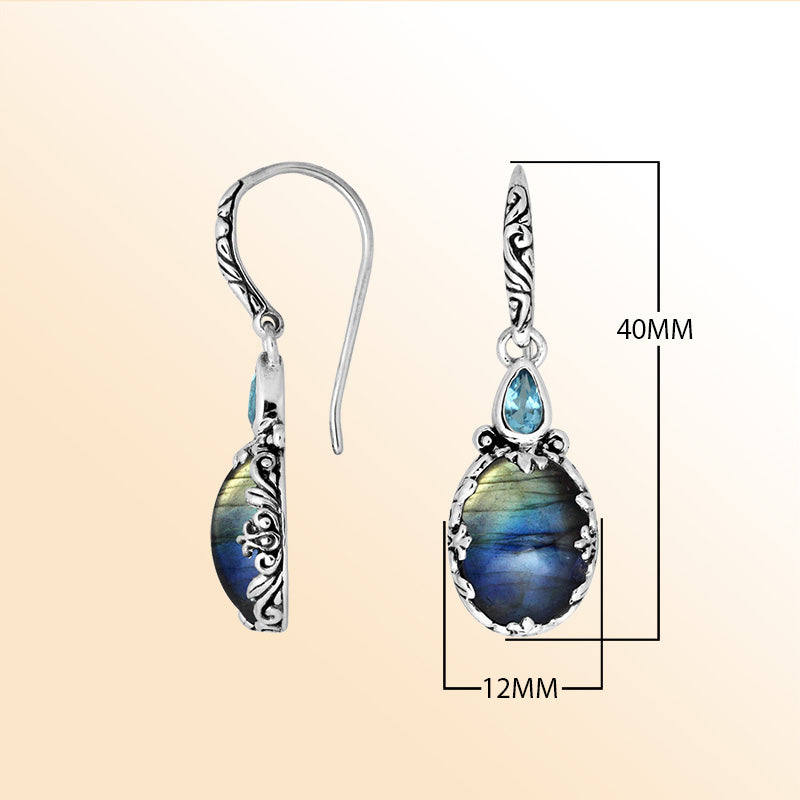 Sterling silver earrings featuring an iridescent Labradorite teardrop paired with a sparkling Blue Topaz Quartz accent, enriched with carved detailing and earwire lock for radiant, mystical everyday elegance.