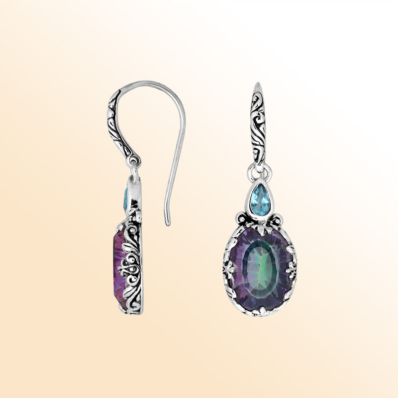 Sterling silver earrings featuring a color-shifting Mystic Quartz oval paired with a sparkling Blue Topaz Quartz accent, enriched with artistic carved borders and earwire lock for radiant handcrafted everyday elegance.
