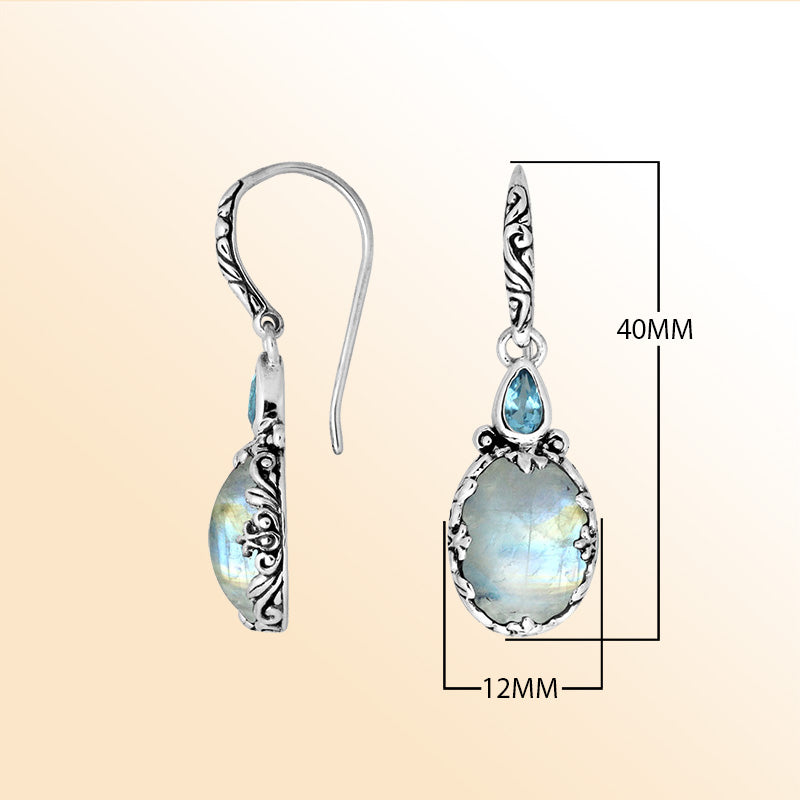 Sterling silver earrings with glowing Rainbow Moonstone paired with a sparkling Blue Topaz Quartz accent, enhanced by carved borders for a radiant everyday handcrafted look.