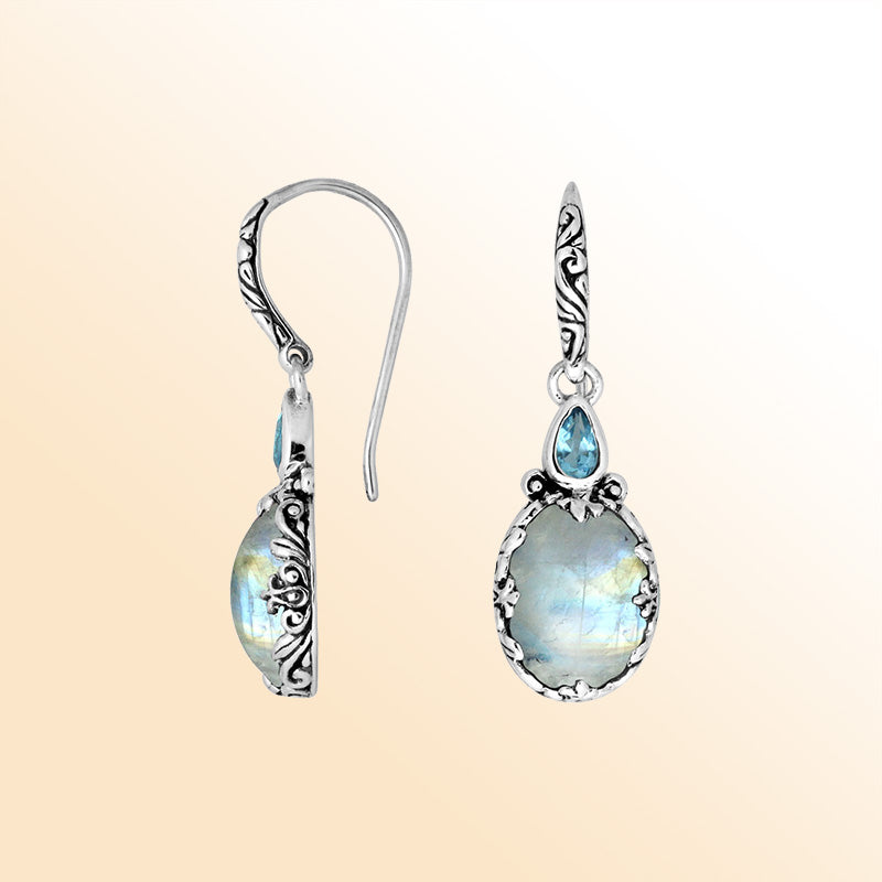 Sterling silver earrings with glowing Rainbow Moonstone paired with a sparkling Blue Topaz Quartz accent, enhanced by carved borders for a radiant everyday handcrafted look.