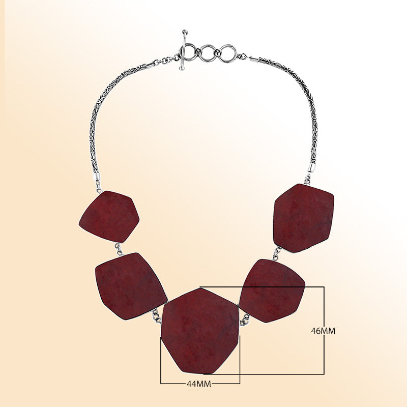 Handcrafted silver necklace with hexagon red coral links in elegant statement design.