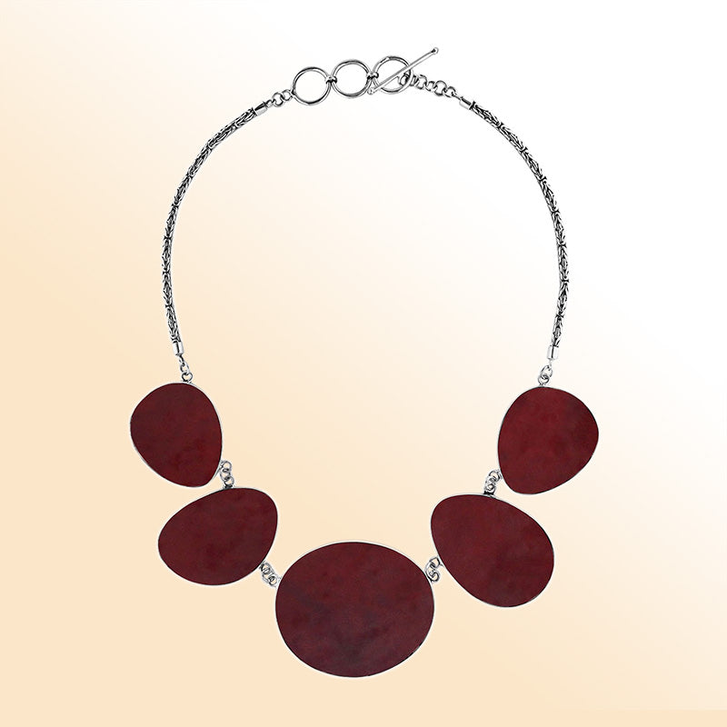 Handcrafted silver necklace with oval red coral links in elegant ocean-inspired design.