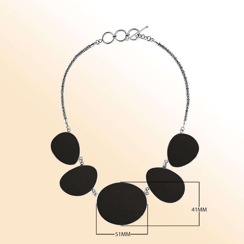 Handcrafted silver necklace with oval black shell links in bold artisan design.