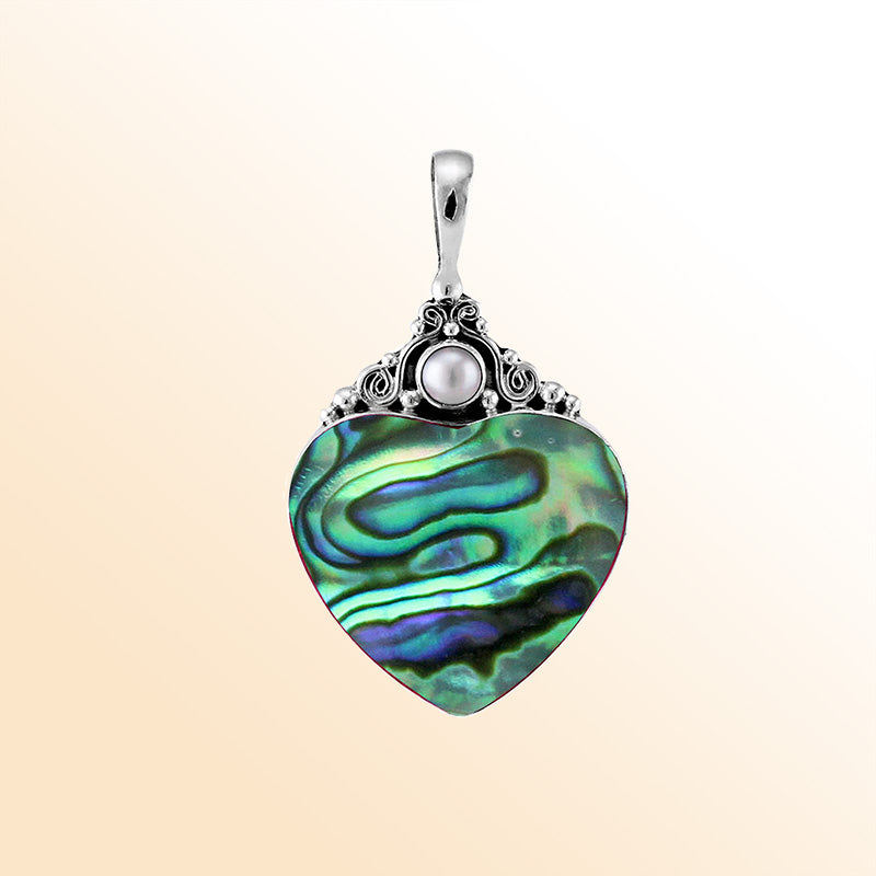 Handcrafted sterling silver heart pendant with shimmering abalone shell and luminous Fresh Water Pearl accent, artisan Bali jewelry with ocean-inspired elegance.
