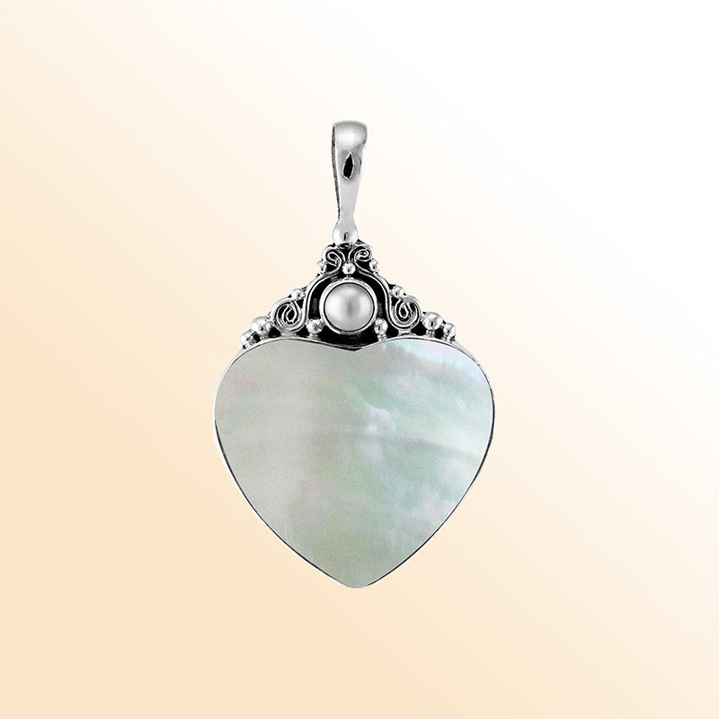 Handcrafted sterling silver heart pendant with luminous Mother of Pearl centerpiece and delicate Balinese scrollwork, artisan jewelry for timeless elegance.