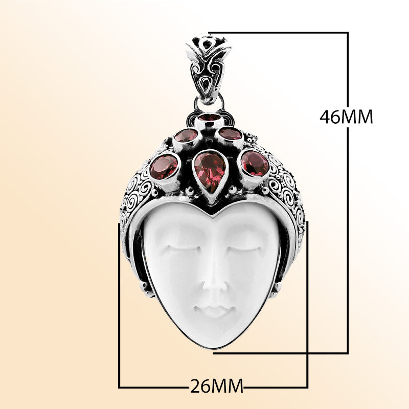 Handcrafted sterling silver pendant featuring a serene goddess face carved from bone with sparkling garnet gemstones, unique Balinese artisan jewelry for women.