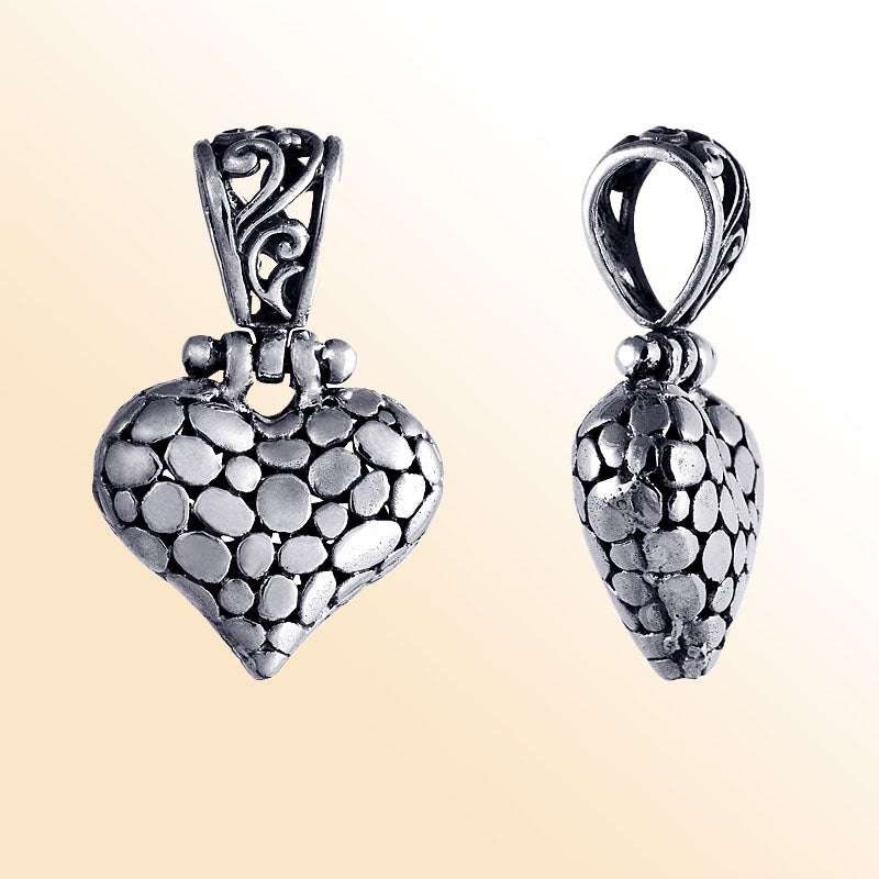 Handcrafted sterling silver heart pendant with textured detailing and ornate Balinese design, a timeless symbol of love and artisan jewelry for women.