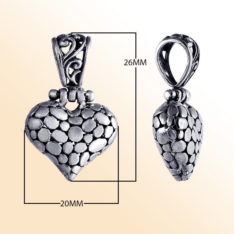 Handcrafted sterling silver heart pendant with textured detailing and ornate Balinese design, a timeless symbol of love and artisan jewelry for women.