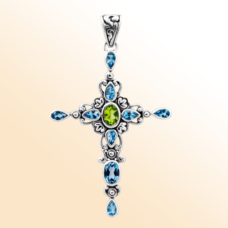 Sterling silver cross pendant with vibrant peridot quartz center and sparkling blue topaz quartz accents, handcrafted Balinese jewelry for faith-inspired style and gifting.
