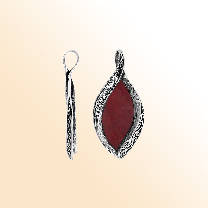 Sterling silver marquise pendant with vibrant red coral inlay and detailed Balinese carving, handcrafted in Bali.