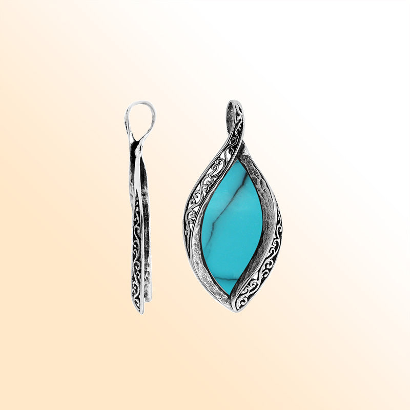 Sterling silver marquise pendant with vibrant turquoise inlay and ornate Balinese carving, handcrafted in Bali.