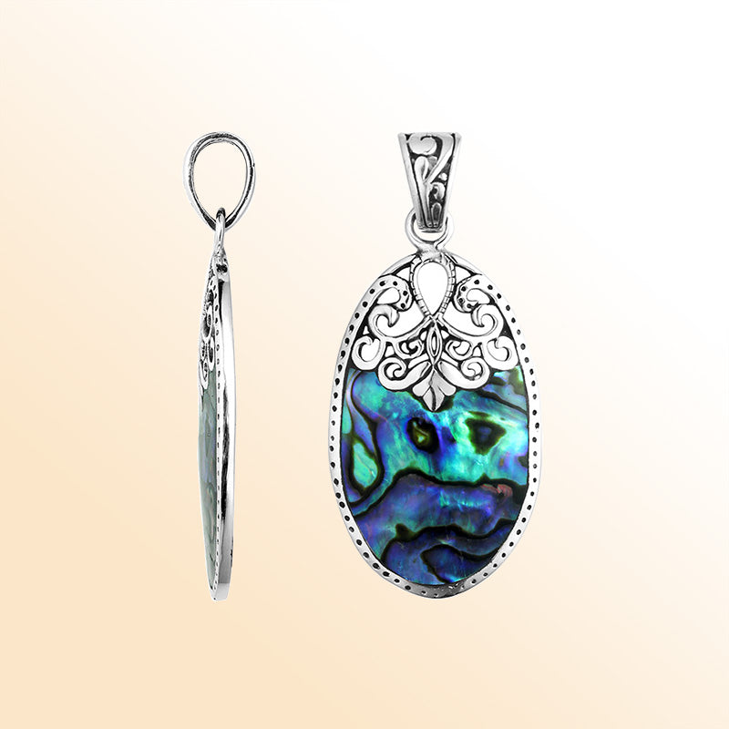 Sterling silver oval pendant with shimmering abalone shell inlay and delicate Balinese filigree detail, handcrafted in Bali.