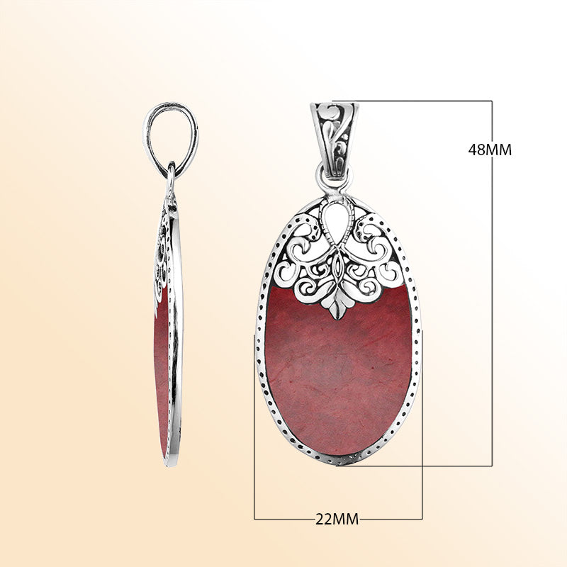 Sterling silver oval pendant with vibrant red coral inlay and delicate Balinese filigree design, handcrafted in Bali.