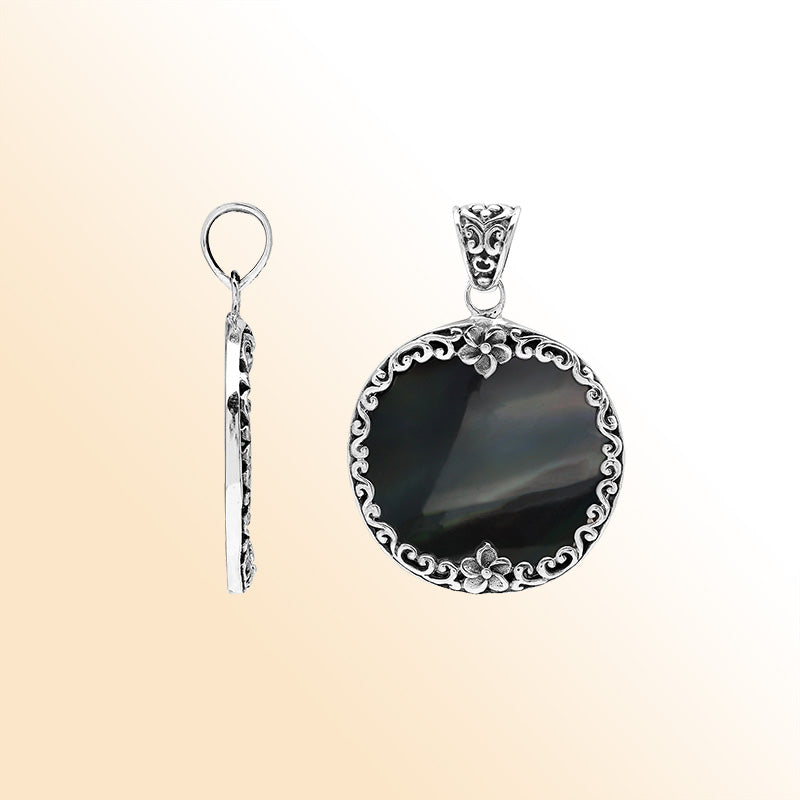 Sterling silver round pendant with glossy black shell and floral Bali detailing, handcrafted artisan jewelry for elegant everyday wear.